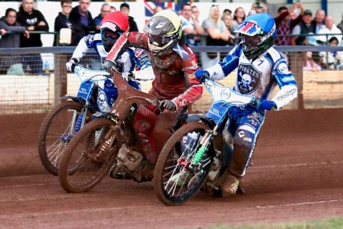 Poole Pirates riders battle for position during a Championship speedway race