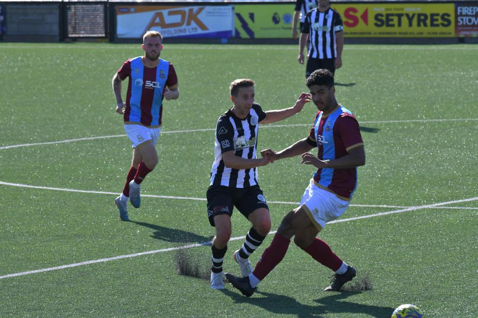 Dorchester Town player challenges Slimbridge AFC defender during Emirates FA Cup qualifying round match